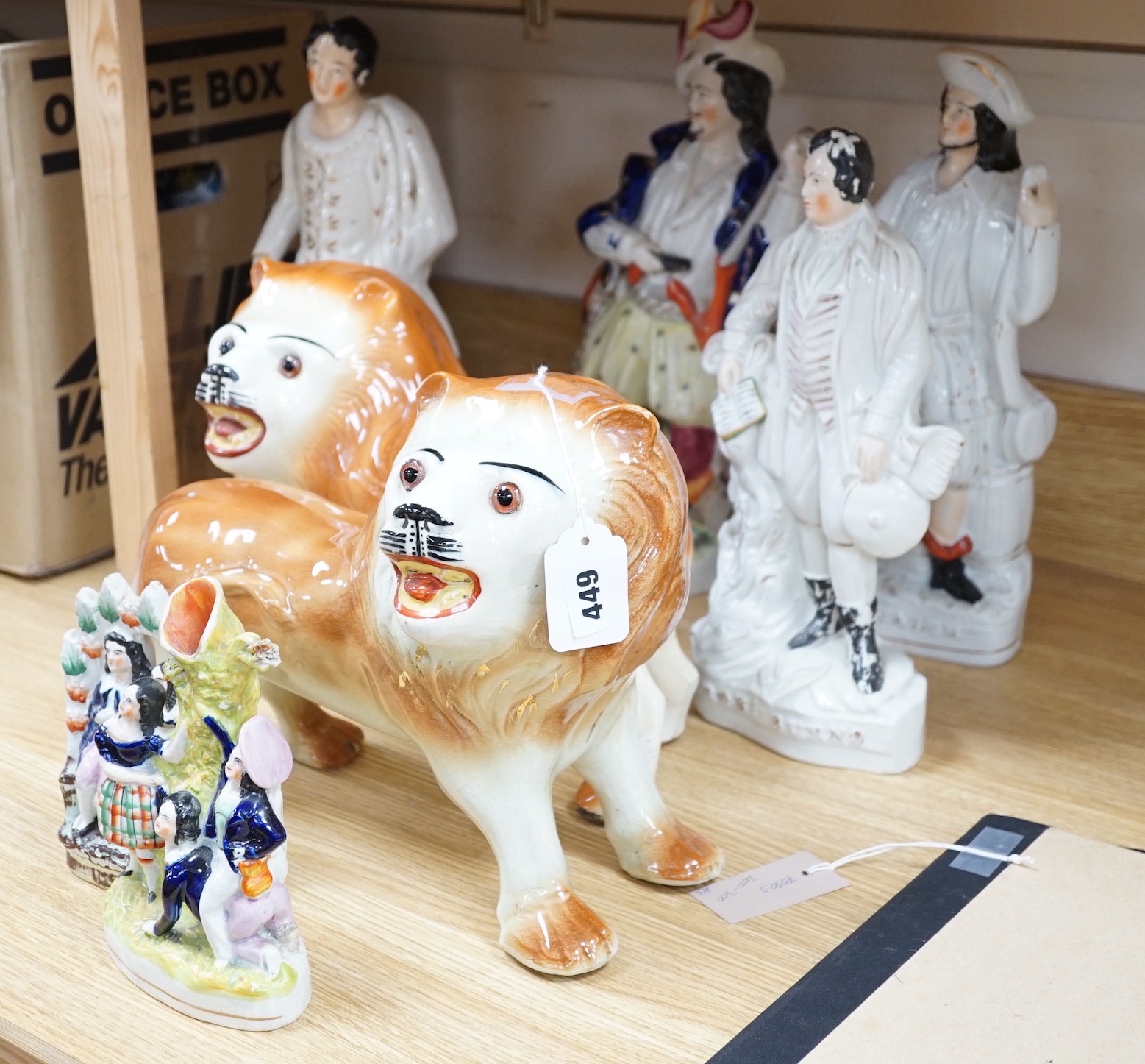 A group of 19th century Staffordshire flat backs and a pair of late Staffordshire pottery lions, 40cms wide